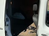 une camionnette blanche dont la porte est ouverte, garée sur le bord de la route