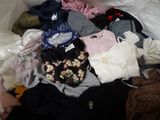 une pile de vêtements sur un lit dans une pièce