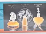 une image représentant une boîte contenant trois flacons de parfum et une figurine en verre