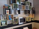 une pièce avec un canapé, une table, une chaise et des étagères au mur