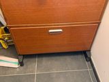 une photo d'une commode dans une salle de bains, sur laquelle se trouvent des feuilles de papier