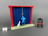 a figurine of a man and a dog in front of a stage