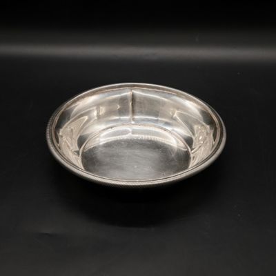 a silver bowl sitting on a black surface