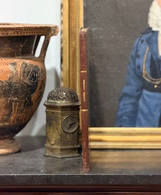une photo d'une femme en robe bleue, à côté d'un vase et d'un livre