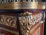 a wooden cabinet with a gold decoration on the top of it