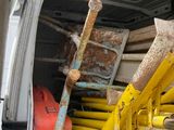 une camionnette blanche avec tout un tas d'outils à l'arrière