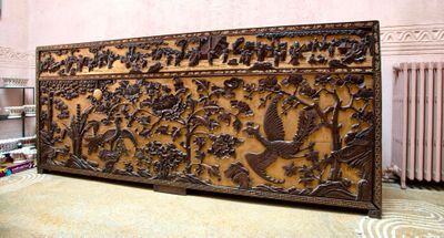 un grand panneau en bois orné d'oiseaux et de fleurs
