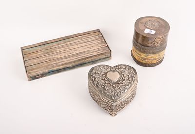 deux boîtes en argent et une boîte en bois posées sur une surface blanche
