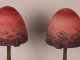 pair of red glass lamps sitting on top of a wooden table