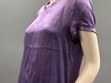 the mannequin is wearing a purple shirt and beige pants