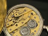 a close up of a pocket watch on a table