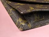 a close up of a wallet on a pink surface