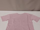 a pink shirt sitting on top of a table next to a pair of scissors