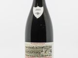 une bouteille de vin rouge posée sur une table blanche