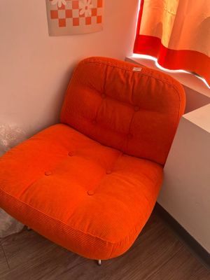 une chaise orange dans un coin de la pièce