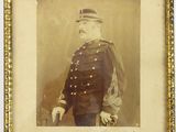 une vieille photo d'un homme en uniforme militaire, dans un cadre doré