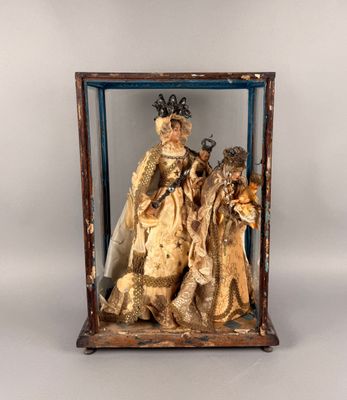 statue représentant un groupe de personnes, exposée dans une vitrine sur fond blanc