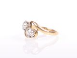 a close up of a gold and diamond ring on a white surface