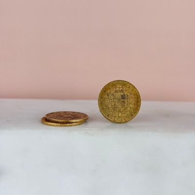 a gold coin sitting on top of a white counter next to a pink wall