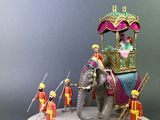 a figurine of an elephant with people on it
