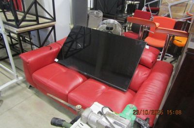 un canapé rouge sur lequel est posé un ordinateur portable, dans une pièce