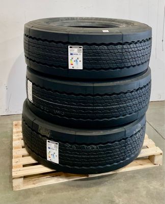 quatre pneus empilés sur une palette dans un entrepôt