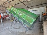 un camion-benne vert qui est garé dans un garage
