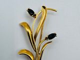une broche en or ornée de pierres noires