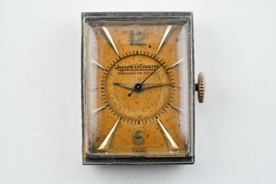 l'image d'une petite montre carrée sur une surface blanche