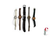 four different watches are lined up on a white surface
