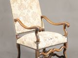une chaise en bois dont l'assise est recouverte d'un tissu beige et blanc