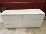 une commode blanche dans une pièce aux murs rouges