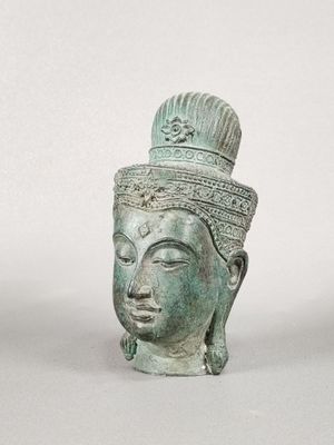 un gros plan sur une statue représentant une tête coiffée d'une couronne