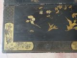 a black and gold box with flowers and leaves on it