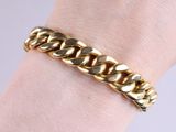 a close up of a person ' s hand wearing a gold chain bracelet