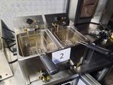 two deep fryers sitting on a table in a kitchen