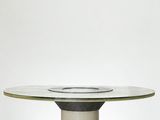 une image représentant une table avec un plateau en verre posée sur une surface noire