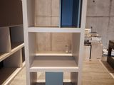 a white bookcase with blue shelves in a room