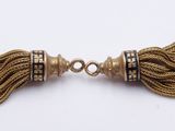 a close up of two tassels on a white surface