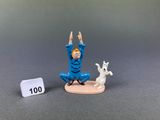 a small figurine of a man doing yoga with a dog
