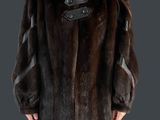La femme porte un manteau de fourrure marron et un jean bleu.