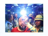 a man taking a selfie with his cell phone in front of a crowd of people