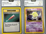 two pokemon cards are shown in plastic cases on a table