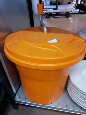 un récipient en plastique orange muni d'un couvercle, posé sur une étagère