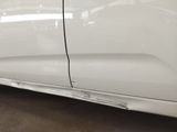 a picture of a white car with a denting on the side