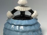 a blue vase with a black and white figure sitting on top of it