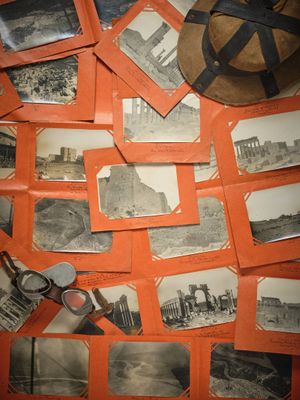 de nombreuses vieilles photos posées sur une table sur laquelle se trouve un chapeau