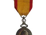 une ancienne médaille avec un ruban rouge sur fond blanc