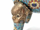 a blue vase with a gold decoration on it