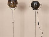 three lamps on a wooden floor in a room with a beige wall